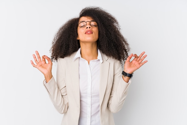 Photo jeune femme d'affaires afro-américaine se détend après une dure journée de travail, elle effectue du yoga.