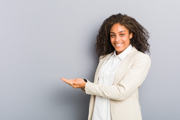 Jeune femme d'affaires afro-américaine tenant un espace de copie sur une paume.