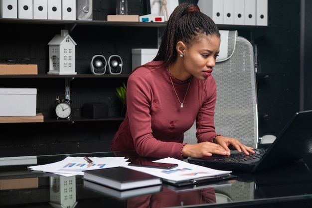 Jeune femme d'affaires afro-américaine travaillant sur ordinateur portable au bureau