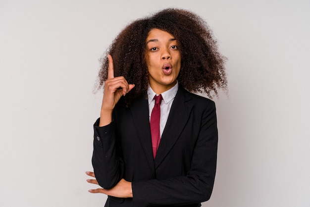 Jeune femme d'affaires afro-américaine vêtue d'un costume isolé sur blanc ayant une excellente idée, concept de créativité.