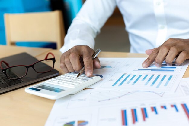 Photo une jeune femme d'affaires asiatique appuie sur une calculatrice pour calculer l'impôt sur le revenu et les revenus des entreprises.