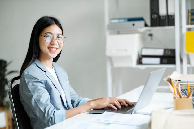 Photo jeune femme d'affaires asiatique ou étudiante travaillant en ligne sur un ordinateur portable