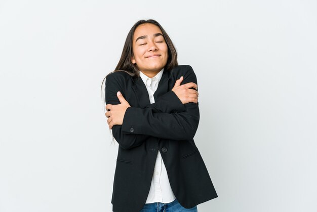 Jeune femme d'affaires asiatique isolée sur des étreintes de mur blanc, souriant insouciant et heureux.