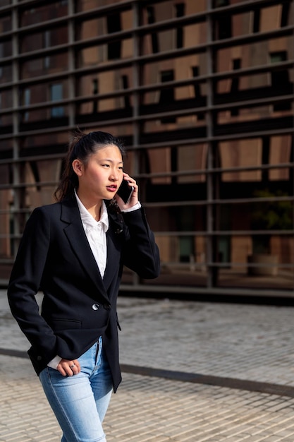 Jeune femme d'affaires asiatique parlant au téléphone