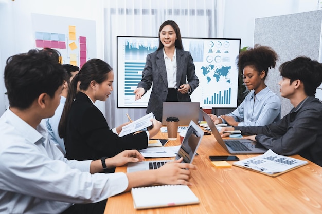 Jeune femme d'affaires asiatique présentant un tableau de bord d'analyse de données sur un écran de télévision dans une réunion moderne Présentation d'affaires avec un groupe d'hommes d'affaires dans la salle de conférence Concord