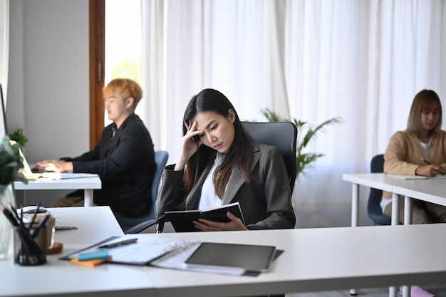 Jeune femme d'affaires asiatique souffrant de stress au bureau.