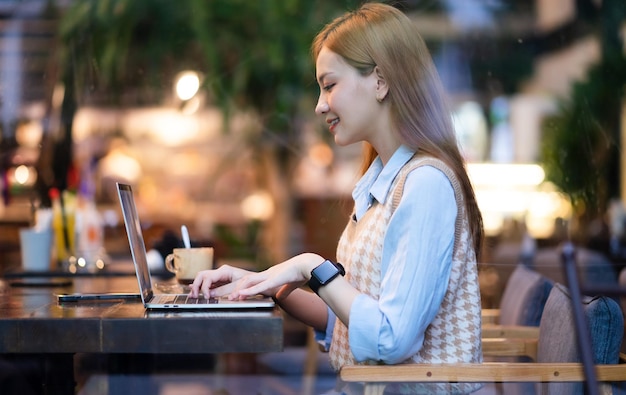 Jeune femme d'affaires asiatique travaillant au café