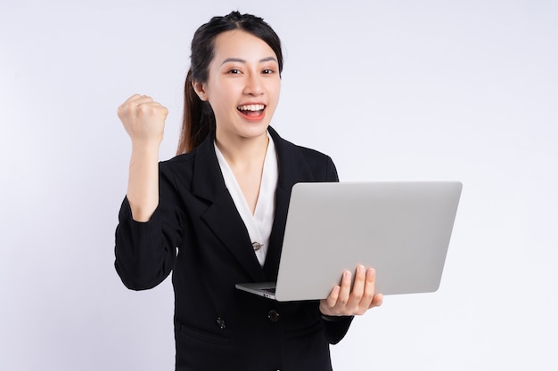 Jeune femme d'affaires asiatique utilisant un ordinateur portable sur fond blanc