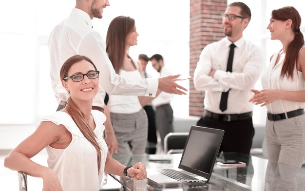 Jeune femme d'affaires assise devant un ordinateur portable ouvert