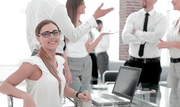 Jeune femme d'affaires assise devant un ordinateur portable ouvert