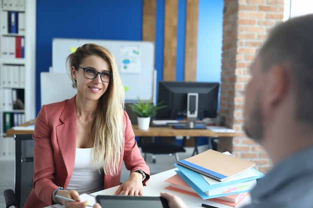 Jeune femme d'affaires au bureau interviewe un homme