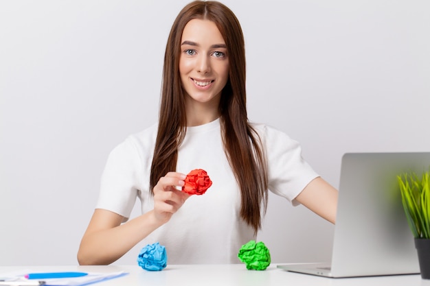 Jeune femme d'affaires au bureau tenant un papier froissé