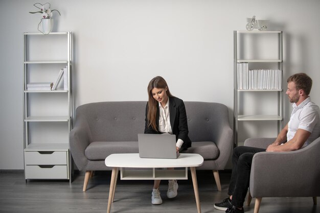 Jeune femme d'affaires et bel homme d'affaires parlant au bureau