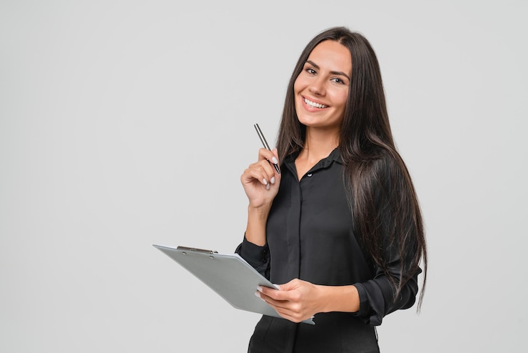Photo une jeune femme d'affaires blanche souriante et confiante, auditeur, écrivant sur un bloc-notes, signant un document de contrat isolé sur un fond blanc.
