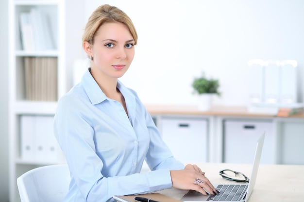 Jeune femme d'affaires blonde avec ordinateur portable au bureau Concept d'entreprise