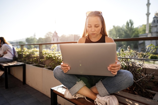 Jeune femme d'affaires blonde utilisant un ordinateur portable travaillant sur la terrasse à istanbul