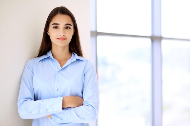 Photo jeune femme d'affaires brune ou étudiante regardant la caméra