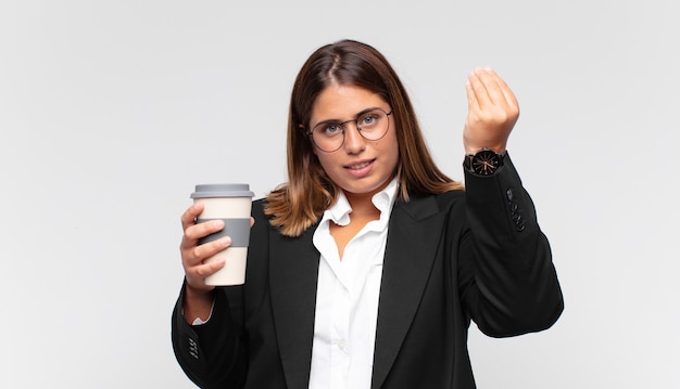 Jeune femme d'affaires avec une capice de café ou un geste d'argent, vous disant de payer vos dettes!