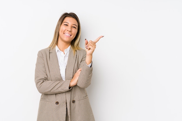 Jeune femme d'affaires caucasien isolé souriant joyeusement pointant avec l'index loin.