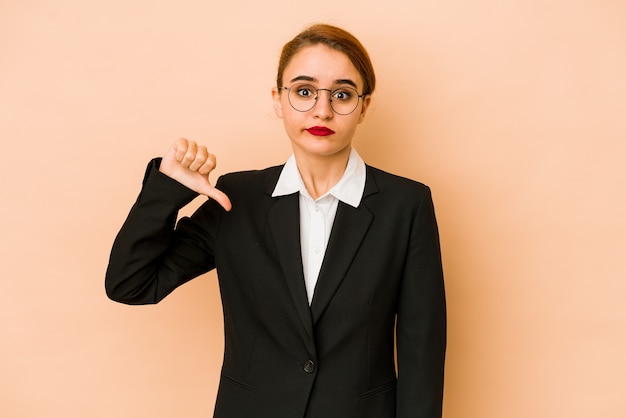 Jeune femme d'affaires caucasienne maigre isolée montrant un geste d'aversion, les pouces vers le bas. Concept de désaccord.