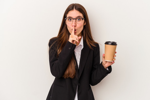 Jeune femme d'affaires caucasienne tenant un café à emporter isolé sur fond blanc gardant un secret ou demandant le silence.
