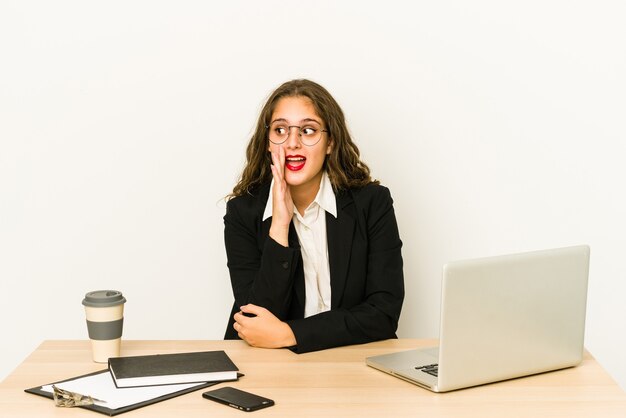 Jeune femme d'affaires caucasienne travaillant sur son bureau isolé