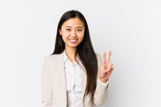 Jeune femme d'affaires chinoise isolée montrant le signe de la victoire et souriant largement.