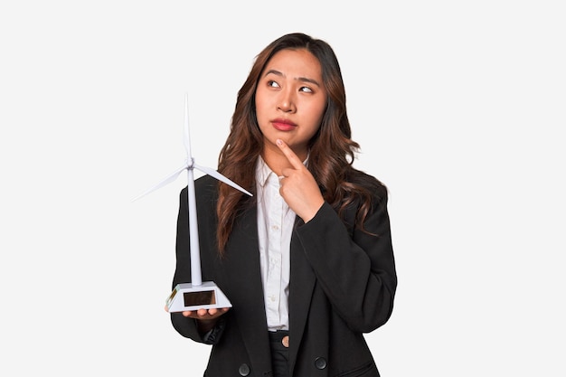Une jeune femme d'affaires chinoise tient fièrement un moulin à vent symbolisant son engagement