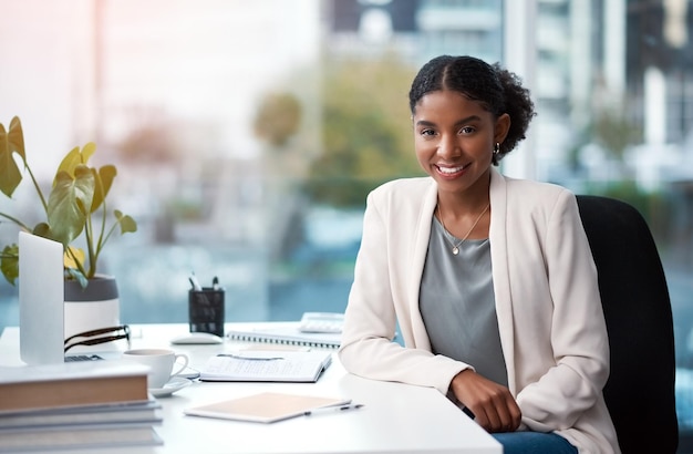 Jeune femme d'affaires confiante et ambitieuse et professionnelle d'entreprise à l'air heureuse, positive et souriante dans son bureau au travail Portrait d'une femme créatrice créative assise à son bureau