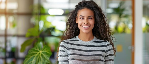 Une jeune femme d'affaires confiante qui dirige un bureau moderne avec de grandes fenêtres et de la lumière naturelle