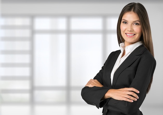 Jeune femme d'affaires en costume sur fond intérieur de bureau flou