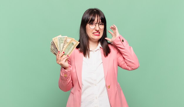 jeune femme d'affaires criant avec les mains en l'air, se sentant furieuse, frustrée, stressée et contrariée