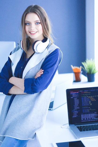 Jeune femme d'affaires debout devant une table au bureau