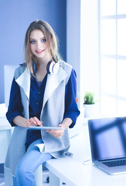 Jeune femme d'affaires debout devant une table au bureau