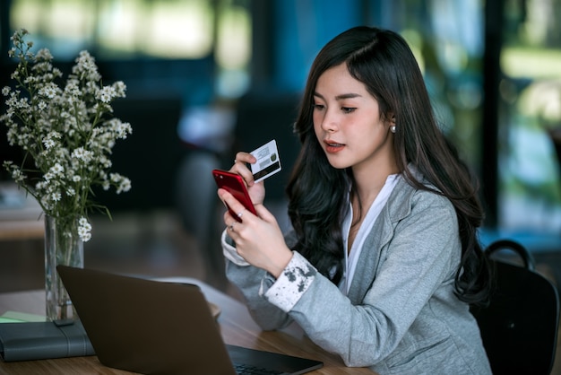 Jeune femme d&#39;affaires détenant une carte de crédit