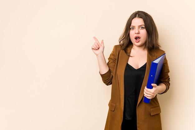 Jeune femme d'affaires détenant des fichiers pointant vers le côté