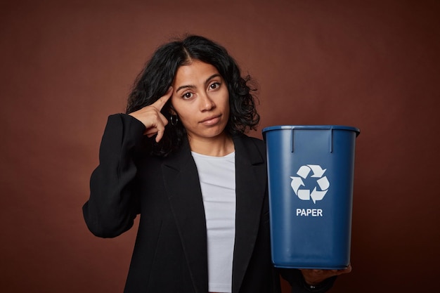 Jeune femme d'affaires embrassant la durabilité avec un bac de recyclage