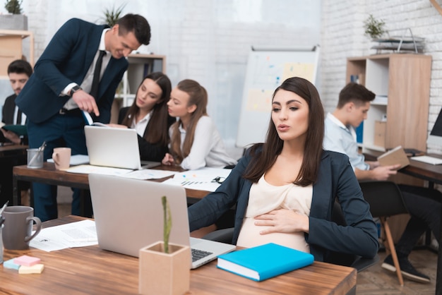 Jeune femme d'affaires enceinte travaillant au bureau