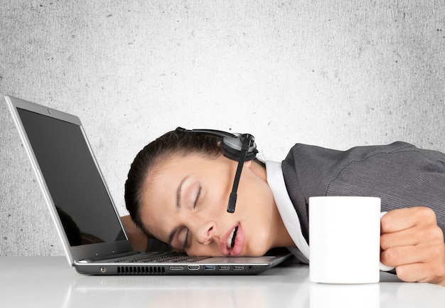 Jeune femme d'affaires endormie avec ordinateur portable