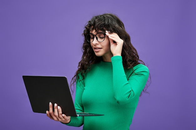 Jeune femme d'affaires ou enseignante à lunettes regardant un écran d'ordinateur portable