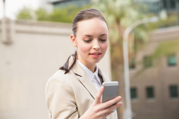 Jeune femme d&#39;affaires envoyant un texte