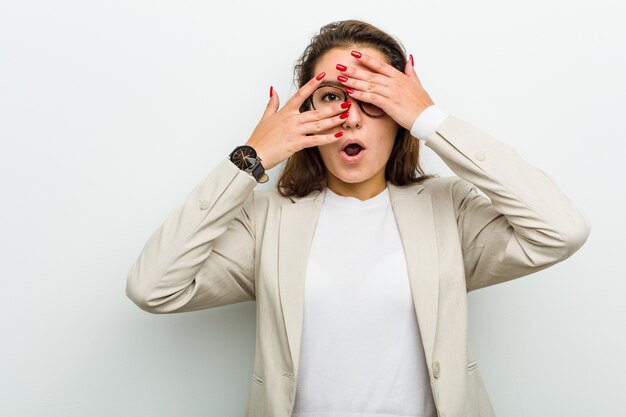 Jeune femme d'affaires européenne clignote entre les doigts effrayés et nerveux.