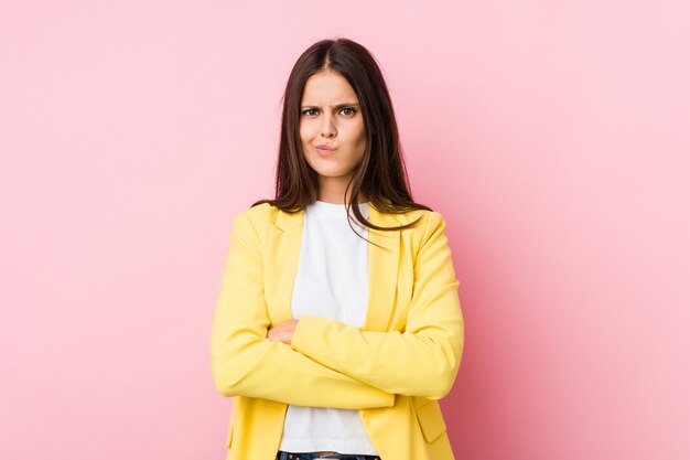 Jeune femme d'affaires fronçant les sourcils de mécontentement, garde les bras croisés.