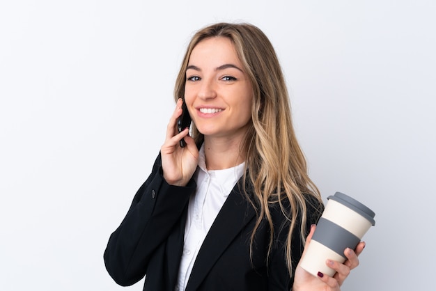 Jeune, femme affaires, isolé, blanc, mur, tenue, tasse, café, téléphone