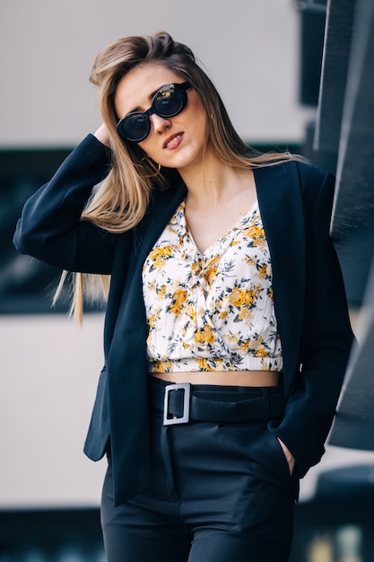 Jeune femme d'affaires en lunettes de soleil et costume