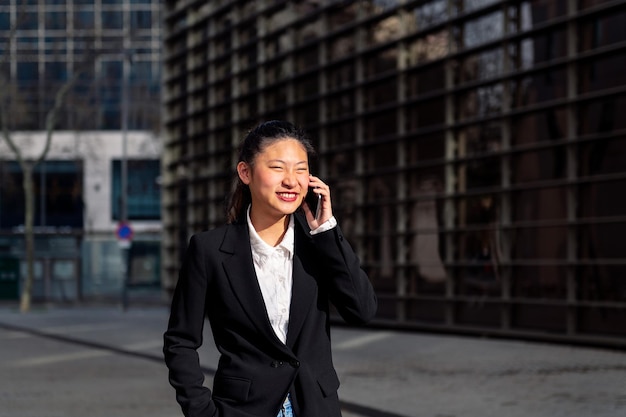 Jeune femme d'affaires marchant parler par téléphone