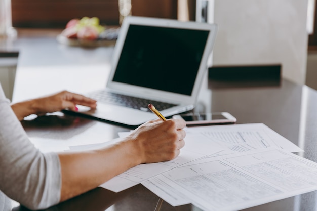 La Jeune Femme D'affaires Moderne Travaillant Avec Des Documents Et Un Ordinateur Portable à La Maison