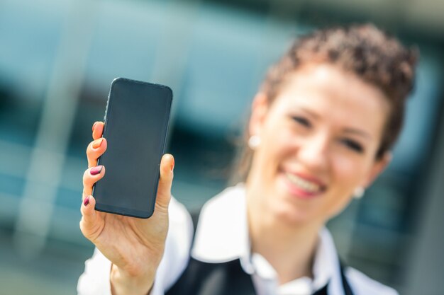 Photo jeune femme d'affaires montrant un téléphone portable