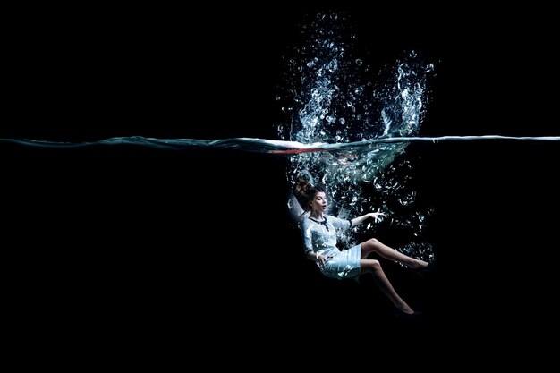 Photo jeune femme d'affaires nageant sous l'eau. technique mixte