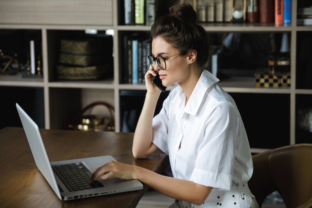 Jeune femme d'affaires parle par smartphone